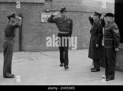 Die Königin hält ihre erste Investitur -- Private William Speakman, V.C., verlässt das Londoner Assembly Center auf dem Weg zum Buckingham Palast, um seine Dekoration zu erhalten. Es ist üblich, dass alle Ränge (einschließlich Offiziere) ein Victoria-Kreuz begrüßen. Hier erkennt der private Speakman die Grüße zweier Offiziere und eines Sergeanten an. Im White and Gold Ball Room des Buckingham Place veranstaltete die Queen heute Morgen die erste Veranstaltung ihrer Herrschaft. Mehr als 100 Personen wurden zum Investure Chief gerufen, darunter der private William Speakman von der Black-Watch. 27. Februar 1952. (Foto von Paul Po Stockfoto