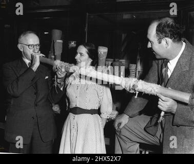 ***** Professor Elkin zeigt Beth Dean und ihrem Mann, wie man ***** spielt Didjeridoo. Solche Instrumente sind in ihrer ethnischen***** wichtig . 12. August 1953. Stockfoto