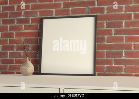 Poster mit quadratischem Rahmen auf dem weißen Tisch mit roter Backsteinwand auf dem Hintergrund Stockfoto