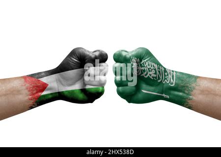 Zwei Hände schlagen sich gegenseitig auf weißem Hintergrund zu. Länderflaggen bemalten Fäuste, Konfliktkrisenkonzept zwischen palästina und saudi-arabien Stockfoto