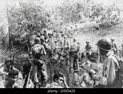 US-Marineinfanteristen ruhen vor der Schlacht auf Guadalcanal -- US-Marineinfanteristen in vollen Rucksäcken und Kampfausrüstung Rufen Sie eine kurze Pause während eines marsches zur Kampffront auf Guadalcanal auf den Salomonen ein. Kurz nachdem das Bild aufgenommen wurde, kamen diese Marines mit japanischen Truppen in den Griff und schlugen sie bei der Verlobung. May0 3, 1943. Stockfoto