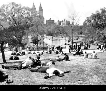 ***** park, wenn gestern die Sonne ***** Lud eine große Menschenmenge in den Park ein, ***** Und Besucher der Stadt. ***** Einige fuhren mit gemieteten Booten zum See, ***** Hier werden Inhalte mit ***** angezeigt Oder auf dem Gras liegen. New Yorks 500 Hektar großer Central Park. . . Eine Zuflucht vor dem Leben auf einer Insel. 05. Dezember 1947. Stockfoto