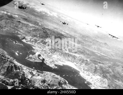 US-Flugzeuge besuchen Hongkong "überraschend" -- Bomber der US Army 14. Air Force besuchen am 16. Oktober 1944 überraschend den in Japan gehaltenen Hafen von Hongkong, um Zerstörung und Tod auf lebenswichtigen feindlichen Anlagen vom Himmel zu fallen. Schiffe im Hafen (links in der Mitte) sind brennend, wenn die Flugzeuge über ihre Ziele fliegen. Eine Rauchsäule bläst sich auch durch einen Großbrand auf, der im Hafengebiet von Kowloon ausbricht (Mitte). Der Hafen an der chinesischen Küste wurde von den Japanern für die Hafenschifffahrt genutzt, ein Großteil davon wurde von den Philippinen und Formosa entfernt, um anderen amerikanischen Luftangriffen zu entkommen. November Stockfoto