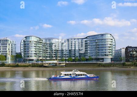 Ein Boot der Thames Clipper fährt am Albion Riverside Gebäude über die Themse in Battersea, London, England, Großbritannien, vorbei. Architekt: Foster und Partner Stockfoto