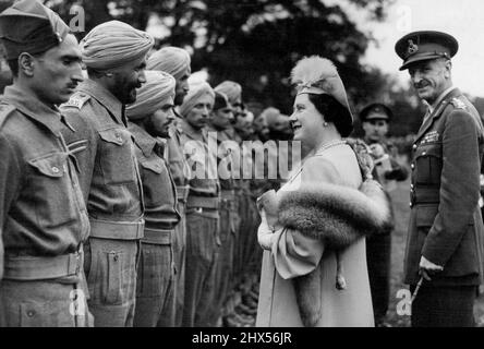 Königlicher Besuch im Rastlager für indische Ex-Kriegsgefangene - die Königin im Gespräch mit einigen der indischen Ex-Kriegsgefangenen. Der König und die Königin besuchten heute ein Lager für ehemalige indische Kriegsgefangene in Thetford, Norfolk, und verabschiedeten sich am Vorabend ihrer Repatriierung von diesen treuen indischen Soldaten, Veteranen der nordafrikanischen Kampagne. 06. Juli 1945. Stockfoto