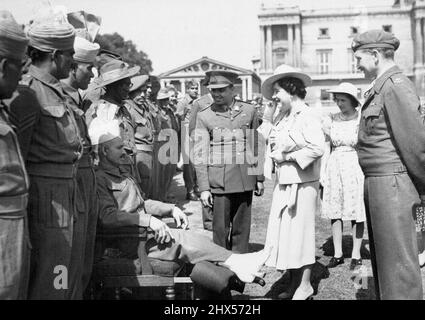 Buckingham Palace Garden Party für Repatriierte Kriegsgefangene - die Königin, der Prinzessin Margaret Rose folgt, hält an, um mit dem Privatmann Umar Hayat vom Royal Indian Army Service Corps zu plaudern. Heute, bei idealen Sommerwetter, wurden Kriegsgefangene von GT zurückgeführt. Großbritannien und die Dominions nahmen an einer Gartenparty im Buckingham Palace Teil, bei der der König und die Königin anwesend waren und viele der Gäste trafen. 19. Juni 1945. Stockfoto