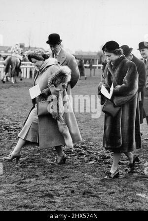 Die Königin und Prinzessin Elizabeth bei Hurst Party Races - HM die Königin tritt vorsichtig über den schlammigen Boden, gefolgt von Prinzessin Elizabeth, während sie und ihre Partei den Kurs überqueren, im Hurst Park. Die Königin flog heute von Sandringham aus, um ihr Pferd Devon Looh beim Rennen im Hurst Park zu beobachten. Sie wurde dort von Prinzessin Elizabeth, die von Clarence Haus fuhr angeschlossen. 17. Januar 1952. (Foto von Fox Photos). Stockfoto