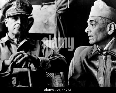 Philippine Chieftains in Conference : der philippinische Präsident Manuel Quezon, der eine Überseekappe trägt, wird rechts gezeigt, wie er General Douglas MacArthur in den ersten Tagen der Schlacht von Luzon im Feldhauptquartier übergibt. Picture ist einer der ersten, der aus der philippinischen Kampfarena kommt. 22. August 1942. (Foto von Interphoto News Pictures, Inc.) Stockfoto