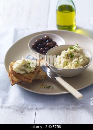 Brandade de Morue (Brandada de Bacalao), püriertes Salz-Kabeljaufstrich, serviert mit Brot und Oliven, auf einem Teller Stockfoto