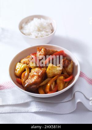 Süßer und saurer Schnapper mit Ananas und roten und orangen Paprika, serviert mit Reis Stockfoto