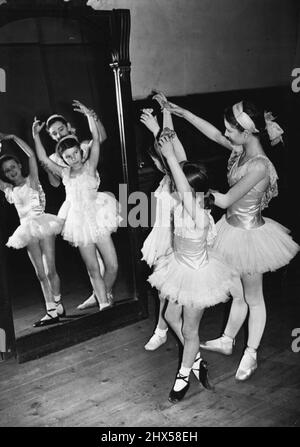 Tanzvorführungen beim Jubilee Dinner - Schüler der Royal Academy of Dancing der Vergangenheit und der Gegenwart geben beim Jubilee Dinner der Academy at Claridge's am kommenden Dienstag (15.. Januar) ein spezielles Programm, das die Entwicklung des Balletts in diesem Land veranschaulicht. Während der Abschlussprobe für die Tanzvorführung beim Abendessen zeigt die junge Tänzerin, die mit Hilfe eines Spiegels unterrichtet wird. 22. März 1946. (Foto von L.N.A.). Stockfoto