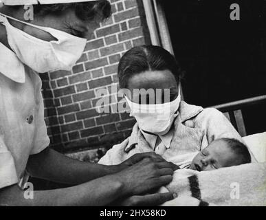 Mansion wird zum Mutterhaus Mutter und Krankenschwestern tragen eine Schutzmaske, wenn das Baby in der frühen Phase behandelt wird. Die ganz jungen Menschen sind leicht Beute von Keimen. 19. September 1951. (Foto von British Official Photograph). Stockfoto