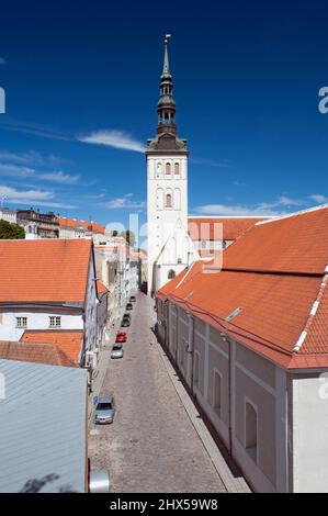 Estland, Tallinn, Niguliste Kirche (St. Nikolaus Kirche) Turm und Turm über Dächer entlang gepflasterten Straße Stockfoto