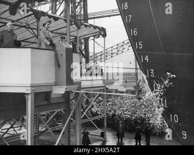 Queen startet das Southern Cross - die Flasche Empire Champagne zerbricht in einem Brunnen aus Flüssigkeit und Glas und der neue Shaw Savill Luxusliner Southern Cross beginnt heute (Dienstag) beim Start von The Queen vom Belfast Yard of harland and Wolff aus den Slipway hinunter zu rutschen. Der verschwendete Mantel von her Majesty und der mit Federn verzierten Hut sind in Pastellgrün gehalten, die dieselbe Farbe haben wie die Oberarbeiten des neuen Liners. Das 20.000-Tonnen-Schiff, auf dem ihr Trichter und Motoren wie ein Öltanker hinten installiert sind, ist für den Dienst zwischen Großbritannien und Australien und Neuseeland vorgesehen. 17. August 1954. Stockfoto