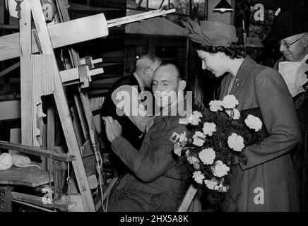 Prinzessin Elizabeth besucht Exeter - Ihre königliche Hoheit Prinzessin Elizabeth besuchte auf einem zweitägigen Besuch in Exeter das St. Loyes College für Behinderte. Prinzessin Elizabeth, die einen neuen Hut trägt, mit geschwungenen Lorbeerblättern trimme, plaudert mit einem der Auszubildenden - einem behinderten Polis-Soldaten - während ihres Besuchs gestern (Mittwoch) am St. Loyes College for the Disabled in Exeter, Devon. 14. November 1946. Stockfoto