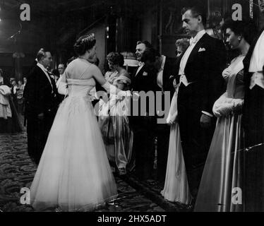 The Royal Film Performance -- H.M. The Queen shaking hands with Peter Finch ebenfalls zu sehen sind Brian Donlevy, Stewart Granger und Jean Simmons. H.M. die Königin, der Herzog von Edinburgh und Prinzessin Margaret nahmen heute Abend an der Präsentation von M.G.M.'s 'Beau Brummell' im Empire Theatre, London, Teil. Der in Elstree produzierte Film ist mit Stewart Granger, Elizabeth Taylor, Peter Ustinov und Robert Morley zu sehen. 15. November 1954. (Foto von L.N.A.) Stockfoto