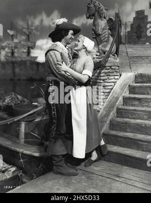 The Exile - Charles (Douglas Fairbanks) und Katie (Paule Croset) machen einen Spaziergang durch den Marktplatz, um die Lastkähne beim Laden zu beobachten. Douglas Fairbanks und Paule Croset, Co-Star mit Maria Montez in 'The Exile' (Lyeeum). 19. Dezember 1947. (Foto von Universal-International). Stockfoto