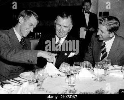 Sir Edmund Hillary, der Eroberer des Mount Everest, zeigte dem Premierminister von Neuseeland, Mr. Holland, mit einer Tischserviette, wie der Aufstieg geplant war, als sie sich heute Abend zum ersten Mal beim Abendessen im australischen Hotel trafen. Rechts ist George Lowe, ein weiteres Mitglied des erfolgreichen Kletterteams. 7. August 1953. (Foto von Frank Albert Charles Burke/Fairfax Media). Stockfoto