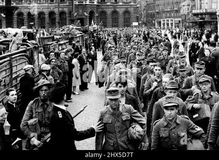 Deutsche Gefangene und belgische Kollaborateure gerafften sich, als die Briten Antwerpen gefangennahmen -- deutsche Gefangene, die durch die Straßen von Antwerpen marschierten, mit dem Hauptbahnhof im Hintergrund. Drei fliegende Säulen britischer Rüstung raste über das frisch befreite Brüssel hinaus und fuhren nach Antwerpen. Die Geschwindigkeit des Vorwärtsfortschritts überraschte die deutschen Verteidiger, und am 4.. September wurde um Mitternacht die Eroberung von Belgiens größter Pert angekündigt. 1. September 1944. Stockfoto