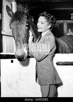 Star Rider -- Stalltür-Einführung für den schönen kanadischen Filmstar Alexis Smith und die Bay Stute Bridget, die sie in vielen Szenen ihres neuen Bildes, 'The Sleeping Tiger', reitet, jetzt in Produktion in den Nettlefold Studios, Walton-on-Thames, Surrey. Dies ist Alexis' erstes britisches Bild für Insignia-Filme. Co-Star ist Dirk Bogarde. 26. Februar 1954. (Foto von Reuterphoto). Stockfoto