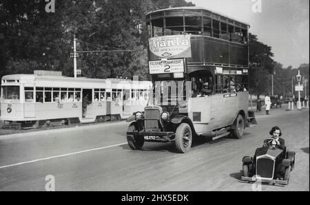 Das kleinste Auto der Welt in Kalkutta -- Es gibt ganz andere Fahrzeuge, die kürzlich in einer Straße in Kalkutta (Indien) gesehen wurden. Links zeigt die moderne Straßenbahn, die jetzt mehr denn je in den Straßen der Stadt beißt, In der Mitte der alten Zeit 'Bus der Doppeldecker-Sorte und rechts die weltweit kleinste Auto von seinem hübschen Besitzer gefahren. Das Auto hat eine Geschwindigkeit von 15 m.p.h. 18. Februar 1935. (Foto von Keystone). Stockfoto