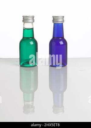 Zwei kleine Flaschen mit grünen und blauen Flüssigkeiten (Lebensmittelfarbstoff), Nahaufnahme Stockfoto