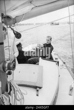 Der Herzog von Edinburgh an Bord der 'Bluebottle' -- die 'Bluebottle', eine Yacht der Dragon-Klasse (ca. 18 Fuß lang) wurde ihren Königlichen Hoheiten Prinzessin Elizabeth. Und dem Herzog von Edinburgh vom Island Sailing Club überreicht. - Der Duke bestritt sein erstes Rennen auf der Yacht, als er bei einer Segelveranstaltung in Cowes in die 'Bluebottle' stieg. In der dreiköpfigen Besatzung der Yacht fungierte der Herzog als dritte Hand. Am ersten Tag wurde 'Bluebottle' Dritter, disqualifizierte sich aber durch Beweidung einer Boje; am zweiten beendete sie 7.. Die 'Bluebottle' segelt auf dem Solent. Danach der Herzog von Edinburgh Stockfoto