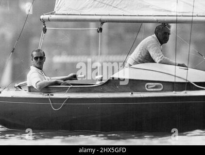 Der Duke Becalmed in Cowes Race -- der Duke of Edinburgh (links) an der Deichsel und Mr. Uffa Fox (Designer des Coweslip) Foto hatten sich heute während des Rennens in Cowes gekalkt. Der Duke of Edinburgh, der an der Cowes Regatta teilnahm, half heute bei der Besatzung seiner Yacht Bluebottle, die er mit der Queen im Dragon Class Race teilt. 6. August 1952. (Foto von Fox Photos). Stockfoto