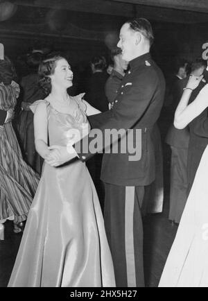 Prinzessin Nimmt An Windsor Ball Teil. Prinzessin Elizabeth lächelt, wenn sie mit Kapitän Joshua Rayley tanzt. Grenadier Wachen am Ball. Prinzessin Elizabeth nahm an dem Ball Teil, der im alten Hotel (erbaut von Sir Christopher Wren) zur Unterstützung des ZK der NSR abgehalten wurde, als sie Mitglied der Gräfin von Gowries Partei war. 20. Juni 1946. (Foto von London News Agency Photos Ltd.). Stockfoto