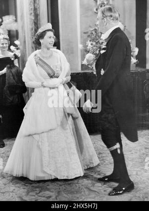 Die Königin An Der Oper. Die lächelnde Königin, strahlend in einem schönen Abendkleid und prächtigem Schmuck, sah gestern Abend im Foyer des Royal Opera House, Covent Garden, im Gespräch mit dem Premierminister Sir Anthony Eden das Kleid eines Ritters der Gartenkünstler tragen. In der letzten Nacht ihres dreitägigen Staatsbesuchs in diesem Land besuchten der Präsident von Portugal, General Craveiro Lopes, und seine Frau Covent Garden, wo sie die Oper "die verbarterte Braut" als Gäste von S.M. der Königin und der königlichen Familie sahen. 28. Oktober 1955. (Foto von Fox Photos). Stockfoto