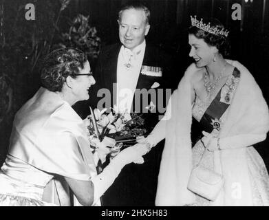 Queen At Commonwealth Concert. Lady White, die Frau des australischen Hochkommissars hier, überreicht der Königin einen Blumenstrauß, als sie in der Royal Festival Hall am Südufer ankommt, Ein Commonwealth-Konzert der Hohen Kommissare von Australien und Neuseeland als musikalische Hommage an die Königin kurz vor ihrer Abreise zu ihrer Commonwealth-Tournee zu besuchen. 21. Oktober 1953. Stockfoto