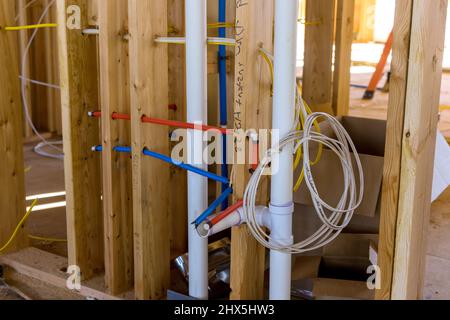 Ein im Bau befindliche neues Gebäude mit einem heiß-roten und kaltblauen Pex-Rohrleitungsnetz aus PVC-Abwasser Stockfoto