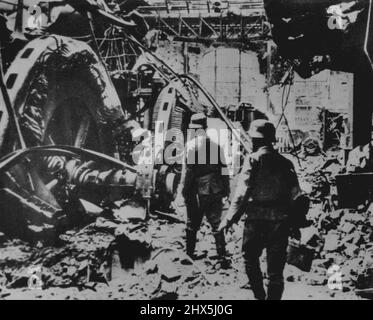 Nazis untersuchen Stalingrad-Schäden -- deutsche Soldaten untersuchen zerstörte deutsche Generatoren in einem beschädigten Stalingrad-Kraftwerk, wie die deutschen Bildunterschriften zu diesem Bild, das heute aus Lissabon hierher kam, zu lesen sind. 9. Januar 1943. (Foto von AP Wirephoto). Stockfoto