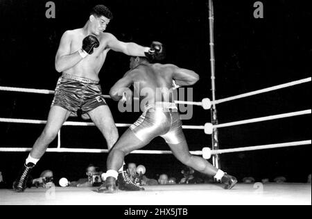 Der riesige südafrikanische Boxer gewinnt den ersten Kampf in London. Der Templer rutscht unter einer geraden Linken von seinem hoch aufragenden Gegner ab. Ewart Potgieter der riesige südafrikanische Boxer besiegte Simon Templar aus Jamaika in ihrem 8 Runden Wettbewerb im White City Stadium in London. Templer - der gegen seinen riesigen Gegner wenig tun konnte - zog sich am Ende der 6.. Runde nach einem schweren ***** zurück Bestrafung. 14. September 1955. (Foto: Sport & General Press Agency, Limited). Stockfoto