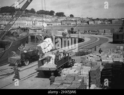 Das Relief von Guernsey und Bark -- Lebensmittel werden am 16.. Mai 1945 in St. Peters Port Guernsey entladen. Die britische Armee lud alle Ladungen ab. Diese Fotografien, aufgenommen am 14.. Und 16.. Mai, zeigen, dass die Menschen in Guernsey und Sark ihre ersten britischen Lebensmittel seit 1940 erhalten haben. Nach dem D-Day hörten auch alle deutschen Lebensmittel für die Inseln auf und die Deutschen fingen sofort an, lebende Bestände zu töten und die Samenkartoffeln der Insel zu essen. Gemüse wurde immer knapper, in Guernsey wurde ein kommunales Futterzentrum eingerichtet, in das jeder brachte, was auch immer sie konnten, Suppe wurde hergestellt Stockfoto