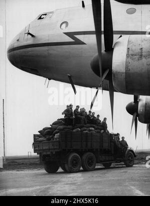 Treibstoff für Berlin durch die Airlift Coalmen -- Ein mit Kohlesäcken beladener Lastwagen fährt in Schleswigland unter der Nase des 'Luftkoalmans', eines riesigen Ha Stings-Flugzeugs. Die ersten der neuen riesigen Luftfrachter, die Royal Air Force Handley Page Hastings, werden nun auf dem Luftzug nach Berlin eingesetzt. Sie werden von der ehemaligen Luftwaffennachtkampfstation in Schleswigland aus in Betrieb gesetzt, wo in den letzten 15 Tagen 19.000 Tonnen Erde entfernt und 7.000 Tonnen Beton verlegt wurden, um den Flugplatz für das riesige Flugzeug bereit zu machen, das die Reise nach Berlin in einer Stunde machen und transportieren kann Eine Last von Stockfoto