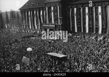 1. Mai in West-Berlin - die Menschenmassen vor dem Rathaus. Unten links befindet sich ein Fallschirm, der mit einer kommunistischen Pest aus dem östlichen Sektor befreit wurde. Zehntausende West-Berliner versammelten sich am 1. Mai vor dem Rathaus von Schdeneberg, um für die Solidität des Westens und die Befreiung der DDR zu demonstrieren. 03.Mai 1955. (Foto von Paul Popper Ltd.). Stockfoto