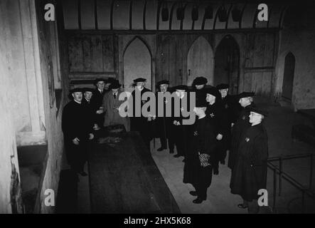 Alte Almshusen Englands: St. Cross Hospital. Das Hospital of St. Cross, in der Nähe von Winchester, Hampshire, wurde vor acht Jahrhunderten von Bischof Henry von Blois gegründet und ist nicht nur für die Schönheit seiner alten Gebäude, Aber für den Fortbestand des Wanderers Dole, das Geschenk eines Horns Bier und ein Silce Brot an Wanderer. Die Brüder erhalten ein wöchentliches Stipendium zusätzlich zu ihren freien Unterkünften. Diese wird in der Brüderhalle verteilt, wie auf unserem Foto zu sehen ist. In der Halle befindet sich ein zentraler Feuerherd für ein Kohlefeuer. 28. März 1939. Stockfoto