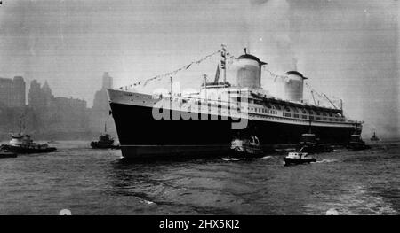 A Queen and her Ladies -- kleine Hafenschiffe begleiten den amerikanischen superliner, die Vereinigten Staaten, an Lower Manhattan vorbei, während das 53.000-Tonnen-Schiff in Rekordzeit den Atlantik in zwei Richtungen erobert. Das 990-Fuß-Schiff machte die Jungfernfahrt in drei Tagen, 10 Stunden und 10 Minuten und die Heimfahrt in drei Tagen, 12 Stunden und 12 Minuten, um neue Rekorde zu erreichen. 15. Juli 1952. (Foto von AP Wirephoto). Stockfoto