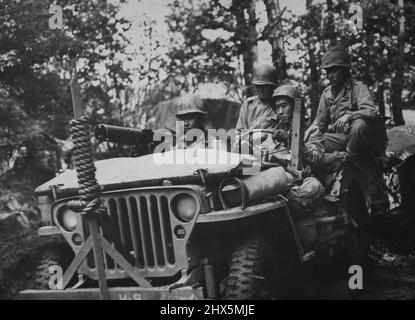 Amerikaner japanischer Descent Jeep entlang Einer Muddy French Road -- mit einem Jeep bewaffnet mit einem schweren Maschinengewehr, beobachten amerikanische Soldaten japanischer Abstammung nach Scharfschützen, während sie sich auf einer schlammigen französischen Straße bewegen. Dahinter wird ein mit Ausrüstung beladener Anhänger geschleppt. Mehrere Tausend dieser jungen Männer, deren Vorfahren aus Japan in die USA kamen, demonstrieren ihre Loyalität, indem sie neben ihren amerikanischen Mitbürgern in Italien und Frankreich gegen den Feind kämpfen. 20. November 1944. (Foto vom US Office of war Information Picture). Stockfoto