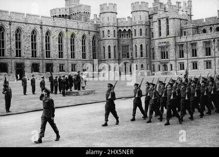 Prinzessin Elizabeth inspiziert Grenadier -- die Wachen marschieren am König im Schloss Windsor vorbei. Die Königin und Prinzessin Elizabeth sind beide auf dem Podium mit ihm. Prinzessin Elizabeth als Oberst des Regiments inspizierte heute das Ausbildungsbataillon der Grenadier Guards in Victoria Barracks, Windsor. Danach ging das Bataillon zum Viereck von Windsor Castle, wo der König, Oberst des Regiments, im vormarsch den Gruß nahm. 7. August 1945. Stockfoto