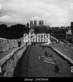 Britische Ansichten -- York - Blick auf die St. Peter's Cathedral, allgemein bekannt als York Minster, und die Stadtmauern von der Lendall Bridge übernommen; die Kathedrale, die ursprünglich von den Normannen gebaut wurde, wurde praktisch komplett in den 12. und 13. Jahrhunderten n. Chr. umgebaut - York ist die Grafschaft Bevölkerung von 105.800. 23. November 1954. (Foto von Hugh Sibley, Camera Press). Stockfoto