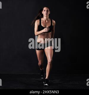 Auf dem Weg zu einem gesünderen Lebensstil. Studioportrait einer Frau, die vor einem dunklen Hintergrund arbeitet. Stockfoto