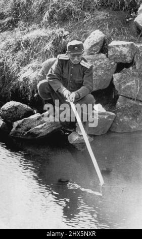 Angeln Sie nach einem roten Hering? -- ein nicht identifiziertes nordkoreanisches Mitglied der kommunistischen Waffenstillstandsverhandlungsgruppe in Panmunjom, Korea, jammers die Zeit während der Sitzung weg, indem es in einem kleinen Bach nahe dem Konferenzort am 14. November fischt. Nordkoreanisches Mitglied der kommunistischen Delegation bei den Waffenstillstandsgesprächen in Panmunjom verbrachte seine Freizeit damit, in einem kleinen Bach in der Nähe des Konferenzortes zu fischen. 18. November 1951. (Foto von AP Wirephoto). Stockfoto