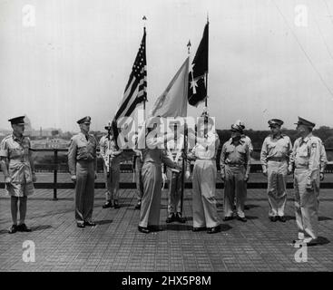 General J. Lawton Collins (links in der Mitte), Stabschef der United States Army, zeigt die blau-weiße Flagge der Vereinten Nationen an den General der Army Douglas MacArthur, Oberbefehlshaber des Fernostkommandos der US-Armee und kommandierender General für die Vereinten Streitkräfte der Vereinten Nationen, die der Republik Korea bei der Verteidigung gegen die nordkoreanische kommunistische Invasion helfen. Die Präsentation fand am Hauptsitz von General MacArthur in Tokio, Japan, statt. 21. August 1950. (Foto: United States Information Service). Stockfoto