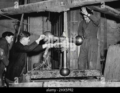 Salisbury's Old Tread-Wheel gewinnt die erste Runde -- das neue Riesenkreuz der Salisbury Cathedral wird von dem jahrhundertealten Laufrad gezogen und erreicht die erste Etappe seiner 404 m langen Reise nach oben. Das mittelalterliche Laufrad im Turm der Kathedrale von Salisbury wurde gestern von einem Gerüst und einem Gehilfen aus dem Boden des Kirchenschiffs mit einem neuen riesigen Kupferkreuz bespannt, das den 404 Meter hohen Turm überragt. Ohne Beanstandung hob das Laufrad, das von Arbeitern des 13. Jahrhunderts verwendet wurde, um Stein und Holz hochzuschleppen, als sie die Kathedrale bauten, langsam das Kreuz mit 1 3/1 cwt durch die Brunnentür im an Stockfoto