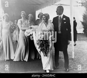 Lady May Cambridge lächelte glücklich, als sie die Balcombe Church, Sussex, mit ihrem Bräutigam, Capt. Abel Smith, verließ. Sie strahlte in ihrem Kleid aus schimmerndem Satin und dem Schleier aus Honiton-Spitze, der von der Königin verliehen wurde, die es auf ihrer eigenen Hochzeit trug. 16. Dezember 1931. Stockfoto