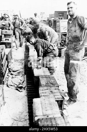 U .S. Streitkräfte treiben Japaner von den Gilbert-Inseln im Pazifik an US-Marineinfanteristen, die an der Eroberung von Tarawa, dem strategischen japanischen Luftstützpunkt auf den Gilbert-Inseln, teilgenommen haben, transportieren mit einem Rollenträger Vorräte über den Sandstrand. US-Streitkräfte trieben auch die Japaner aus dem angrenzenden Gebiet, was die alliierten Führer versprochen haben, dass es nicht enden wird, bis die Japaner aus allen Gebieten vertrieben wurden, die sie seit 1895 erworben haben. 24. Januar 1944. Stockfoto