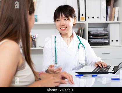 Asiatische Ärztin, die mit Patienten arbeitet Stockfoto