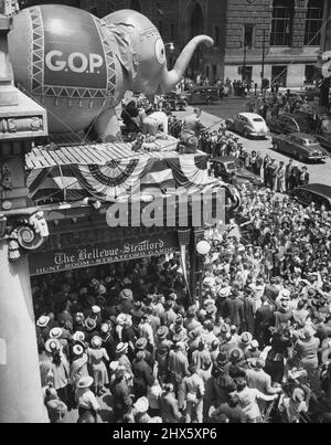 The Mob Follows the Elephant – Hier ist ein Teil der Menschenmenge, die sich vor dem Bellevue-Startford Hotel in Philadelphia, Pennsylvania, im Juni 20 versammelt hat, um Govdewey und andere republikanische Berühmtheiten bei der Ankunft zur Nationalversammlung zu beobachten. Der Ballonelefant auf dem Festzelt des Hotels, der unter verschiedenen Deflationsstadien litt, ist nach einem Pumpenjob wieder auf den Beinen. 20. Juni 1948. (Foto von Associated Press Photo).;The Mob folgt dem Elefanten -- Hier ist ein Teil der Menge, die sich vor dem B versammelt hat Stockfoto